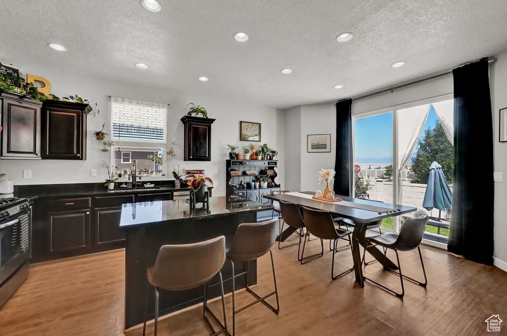 Kitchen featuring a center island, light hardwood / wood-style floors, dark stone countertops, and a textured ceiling