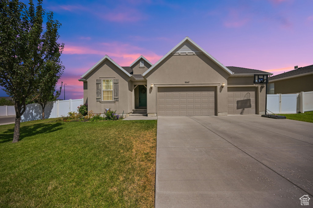 View of front of house featuring a garage and a lawn