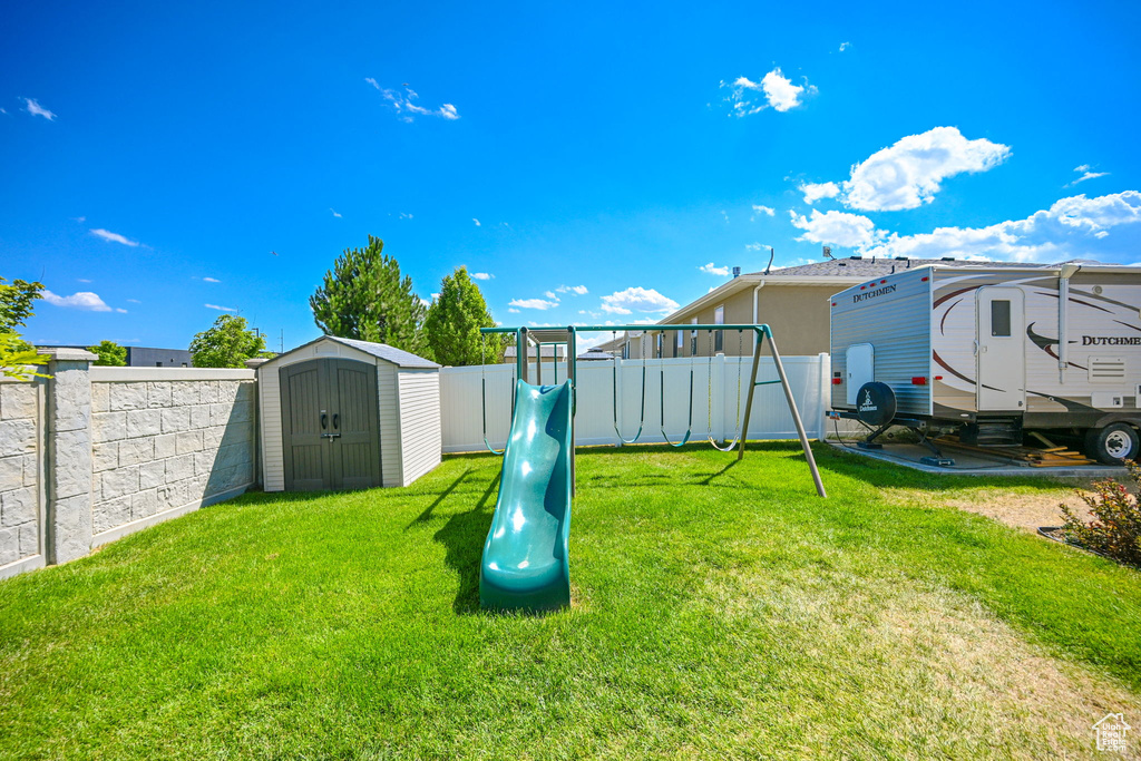 View of yard featuring a storage shed and a playground