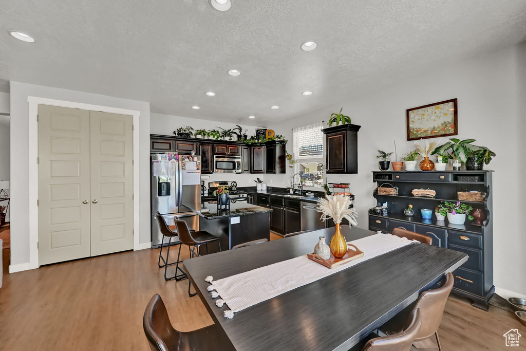 Dining space featuring sink, a textured ceiling, and light hardwood / wood-style flooring