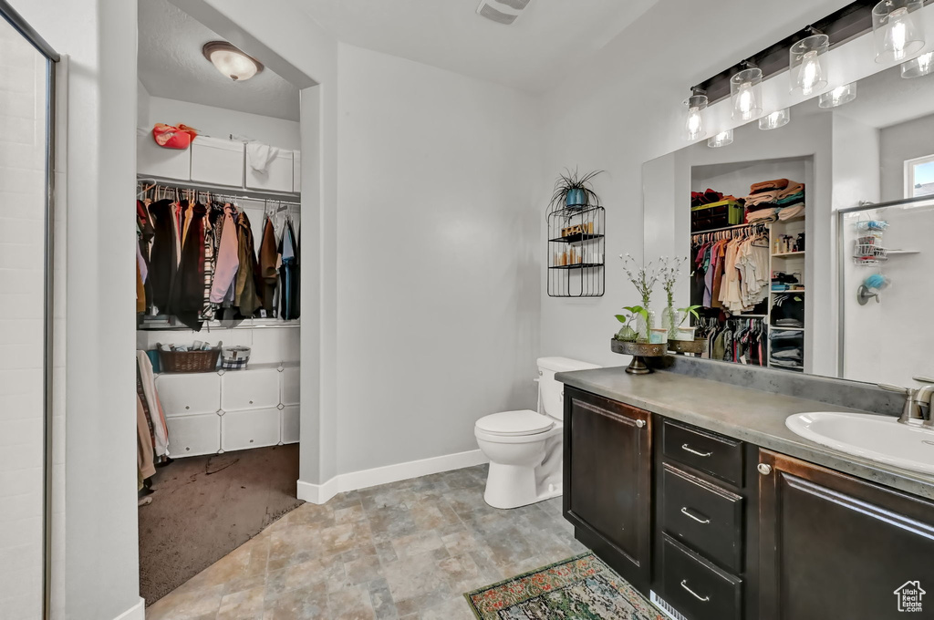 Bathroom featuring vanity, tile patterned flooring, and toilet