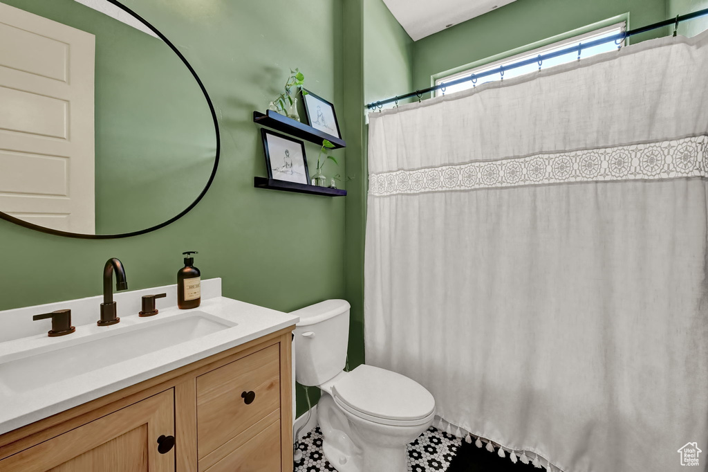 Bathroom featuring vanity, tile patterned flooring, and toilet