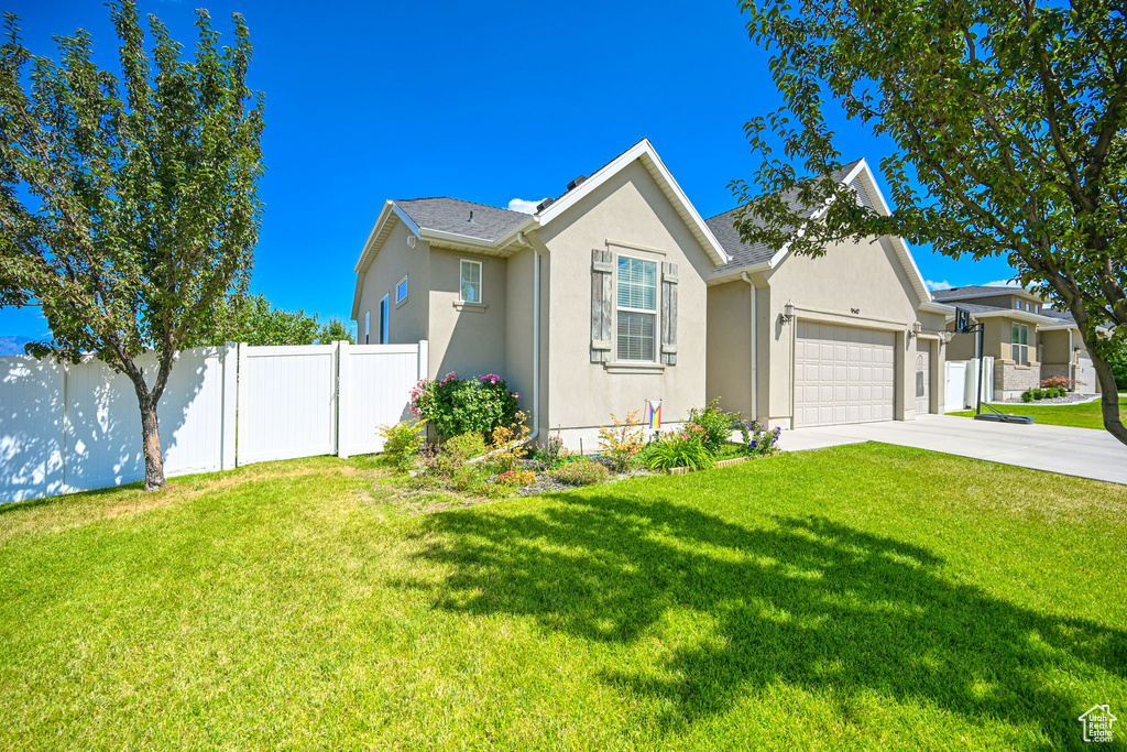 View of front of property featuring a garage and a front yard