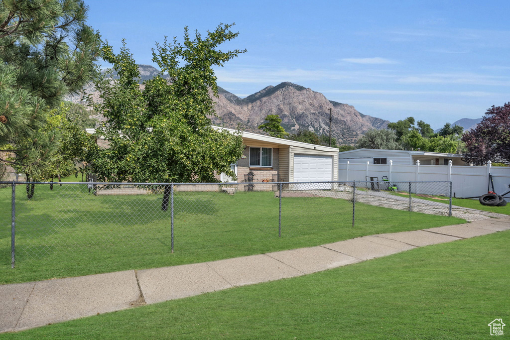 View of front of house featuring a mountain view and a front lawn