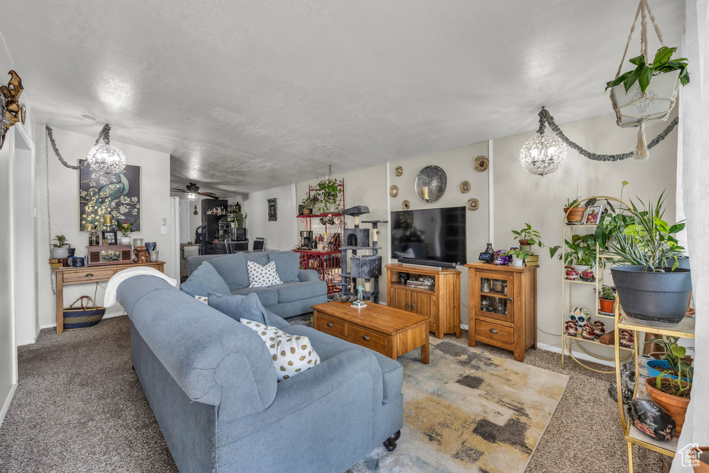 Living room featuring carpet floors and ceiling fan with notable chandelier