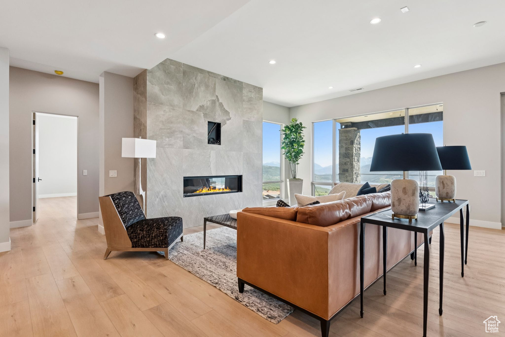 Living room featuring light wood-style floors, recessed lighting, and a fireplace