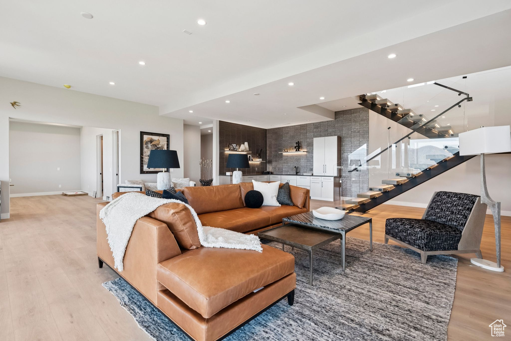 Living area with light wood-type flooring, stairway, and recessed lighting