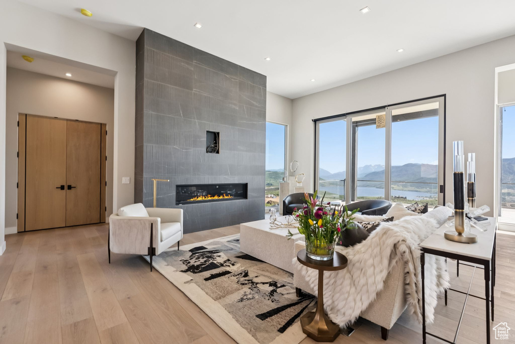 Living room featuring light wood-style floors, a tiled fireplace, a mountain view, and recessed lighting