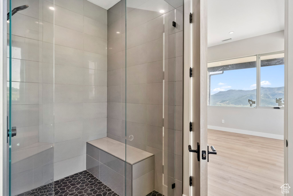 Bathroom featuring tiled shower, wood finished floors, and a mountain view