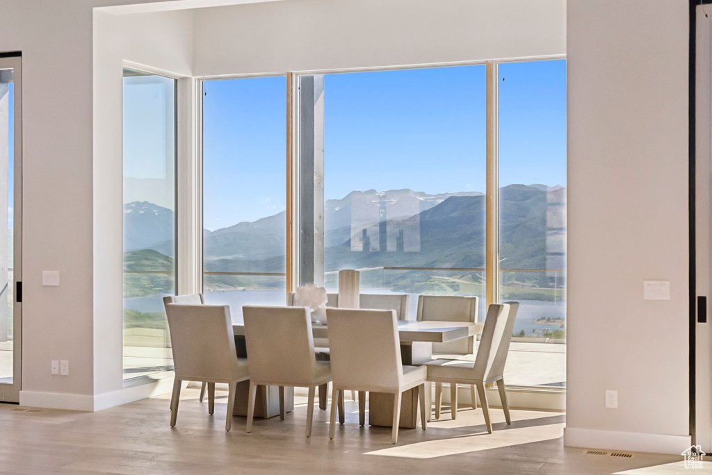 Dining space with plenty of natural light, a mountain view, and wood finished floors