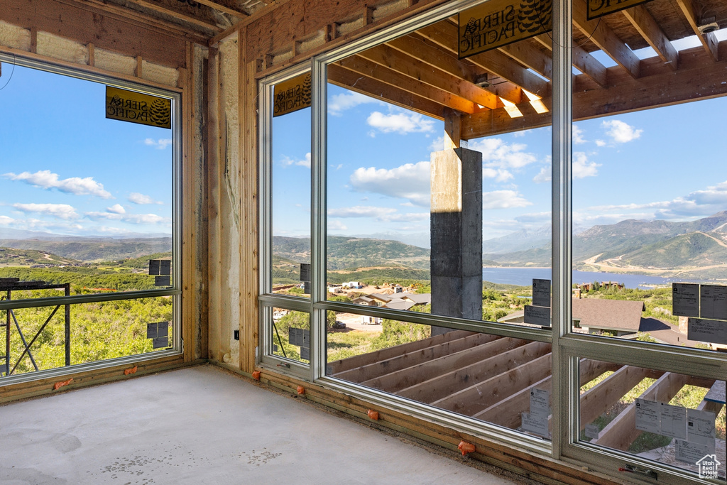 Unfurnished sunroom with a water and mountain view and plenty of natural light