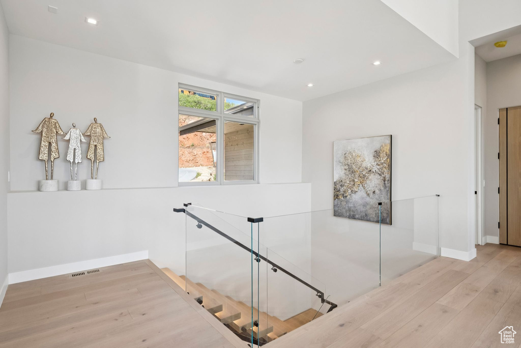 Corridor with wood finished floors and recessed lighting