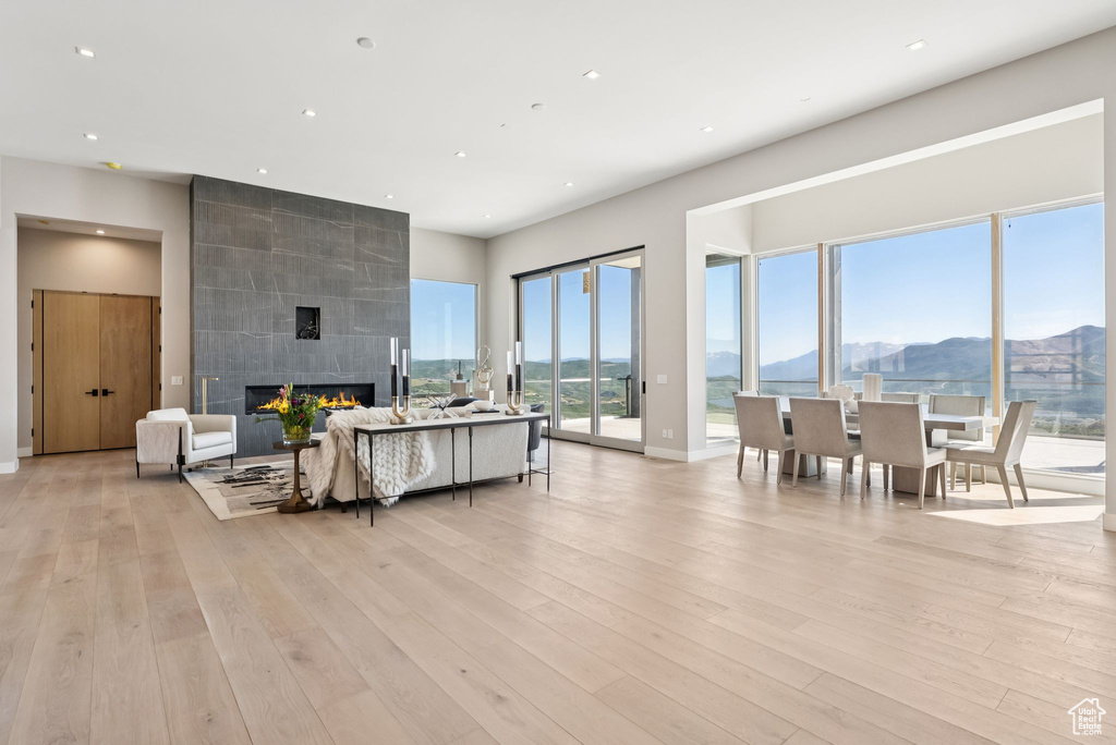 Living area featuring a mountain view, light wood-style flooring, a large fireplace, and recessed lighting