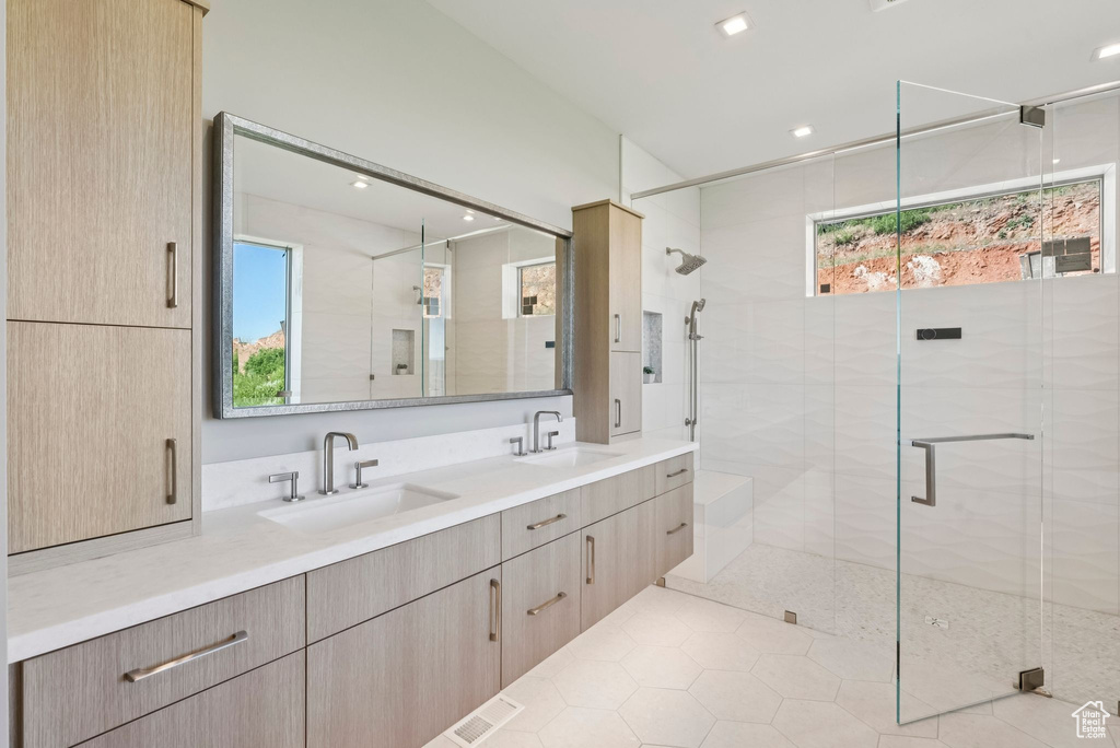 Full bath with a shower stall, double vanity, tile patterned floors, and recessed lighting