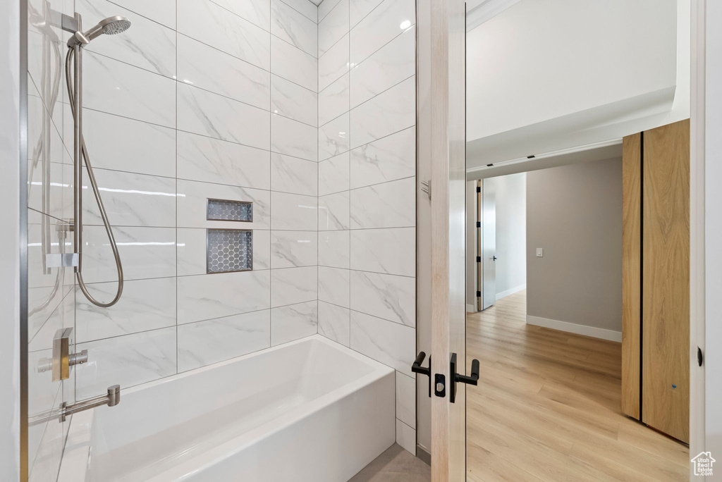 Bathroom featuring wood finished floors and shower / washtub combination