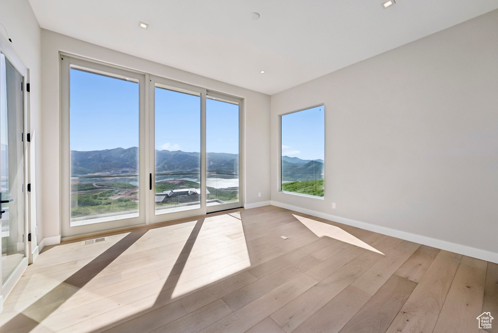 Spare room featuring a mountain view, wood finished floors, and recessed lighting