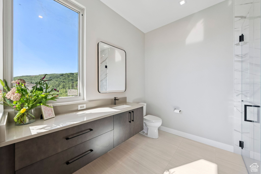 Full bath featuring vanity and a marble finish shower