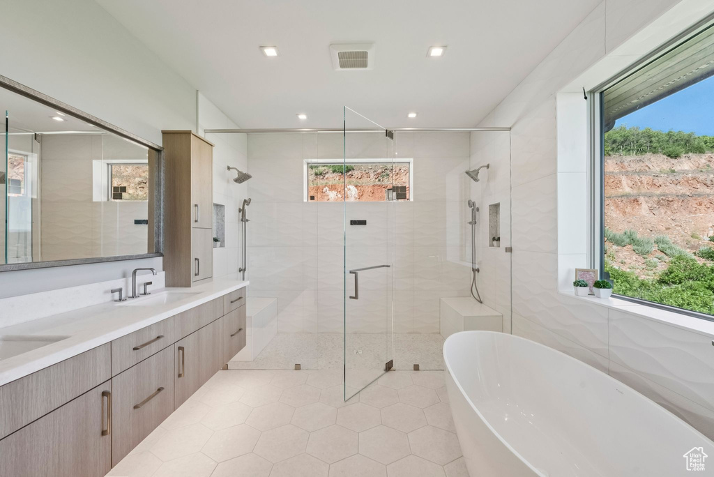 Full bath with plenty of natural light, a soaking tub, and recessed lighting