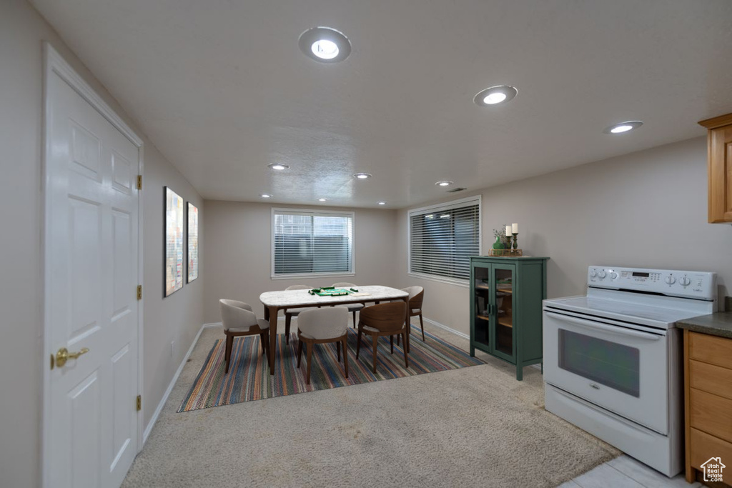 Kitchen featuring white range with electric cooktop and carpet