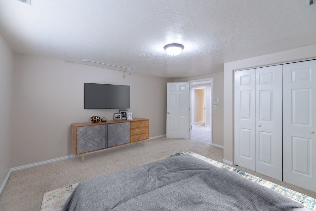 Carpeted bedroom featuring a closet and a textured ceiling