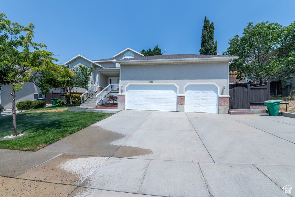 View of front of home with a garage and a front lawn