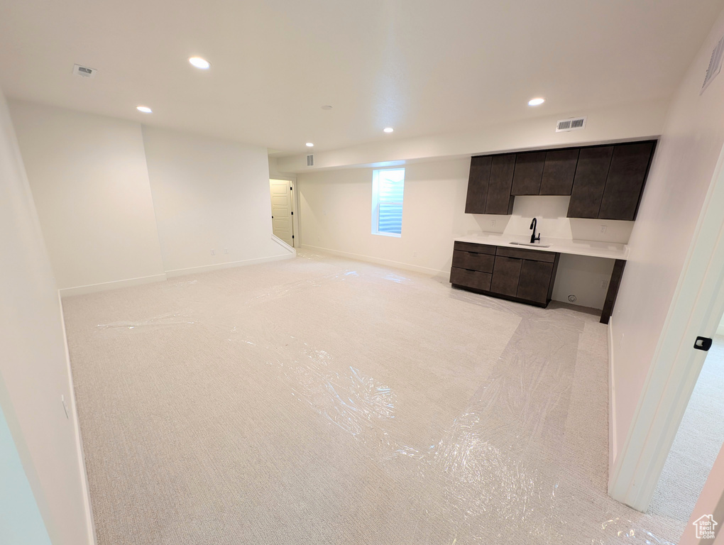 Basement featuring light carpet and sink