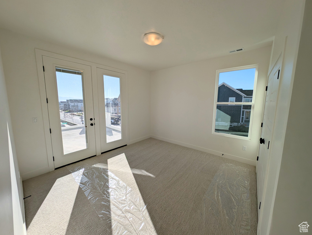 Carpeted empty room with french doors