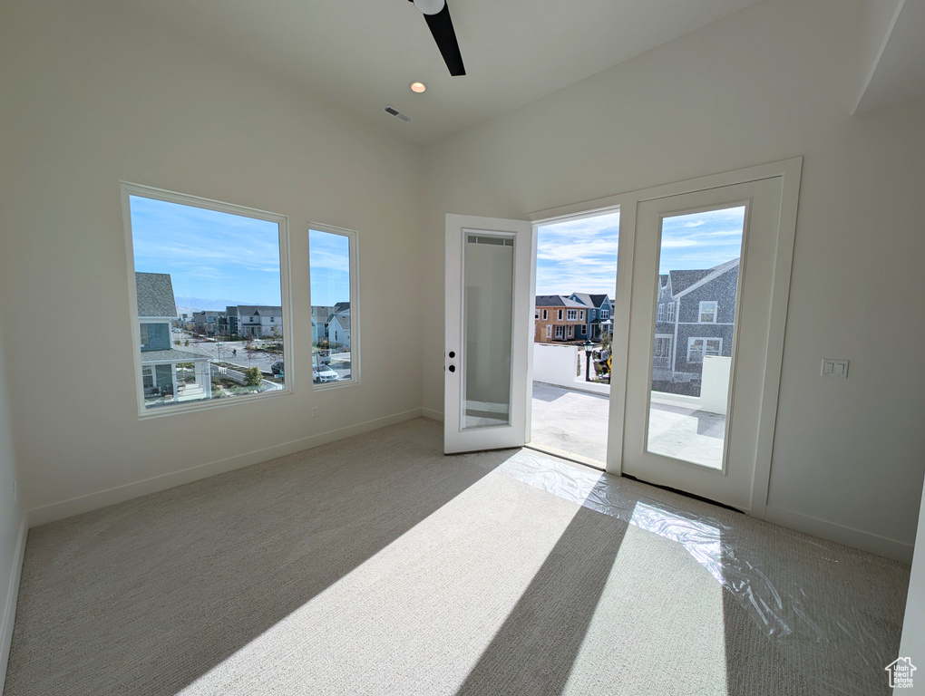 Spare room featuring light colored carpet and ceiling fan