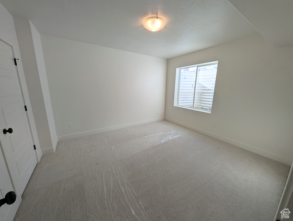 Carpeted spare room with a textured ceiling