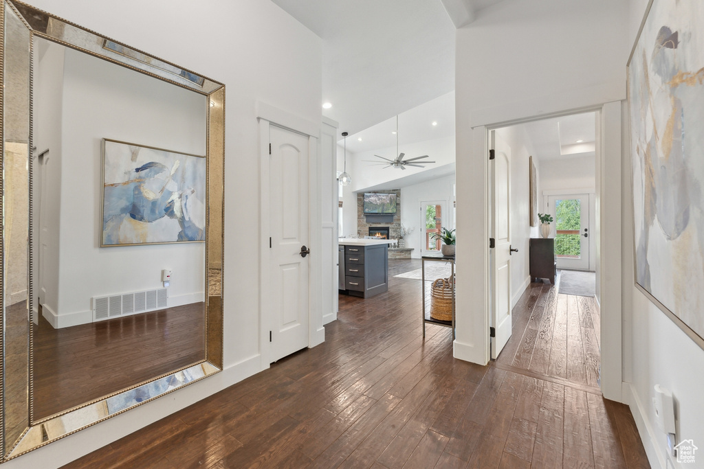 Hall with dark hardwood / wood-style flooring and high vaulted ceiling