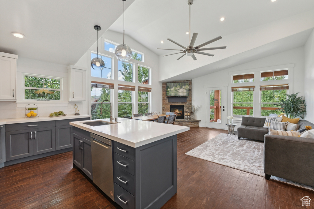 Kitchen with dark wood-type flooring, a fireplace, ceiling fan, and lofted ceiling