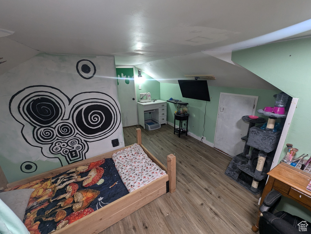 Bedroom featuring hardwood / wood-style flooring and vaulted ceiling