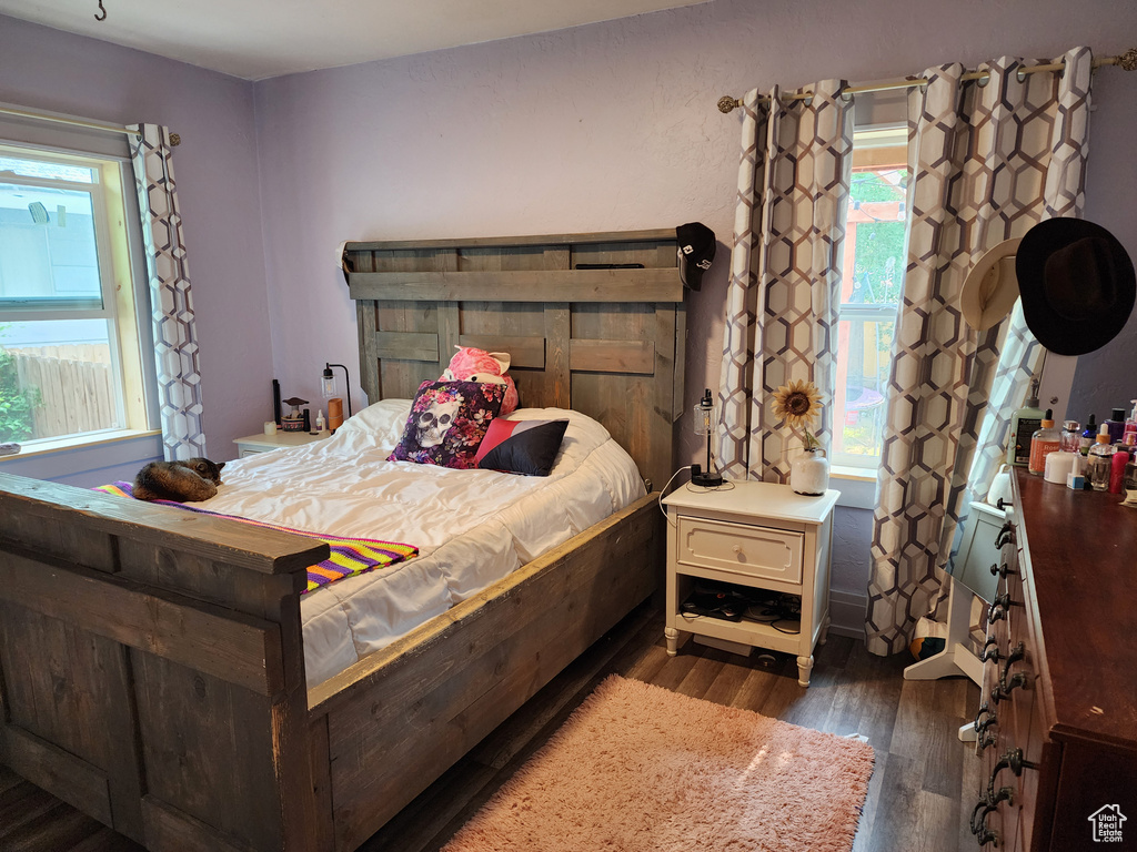 Bedroom with dark hardwood / wood-style flooring