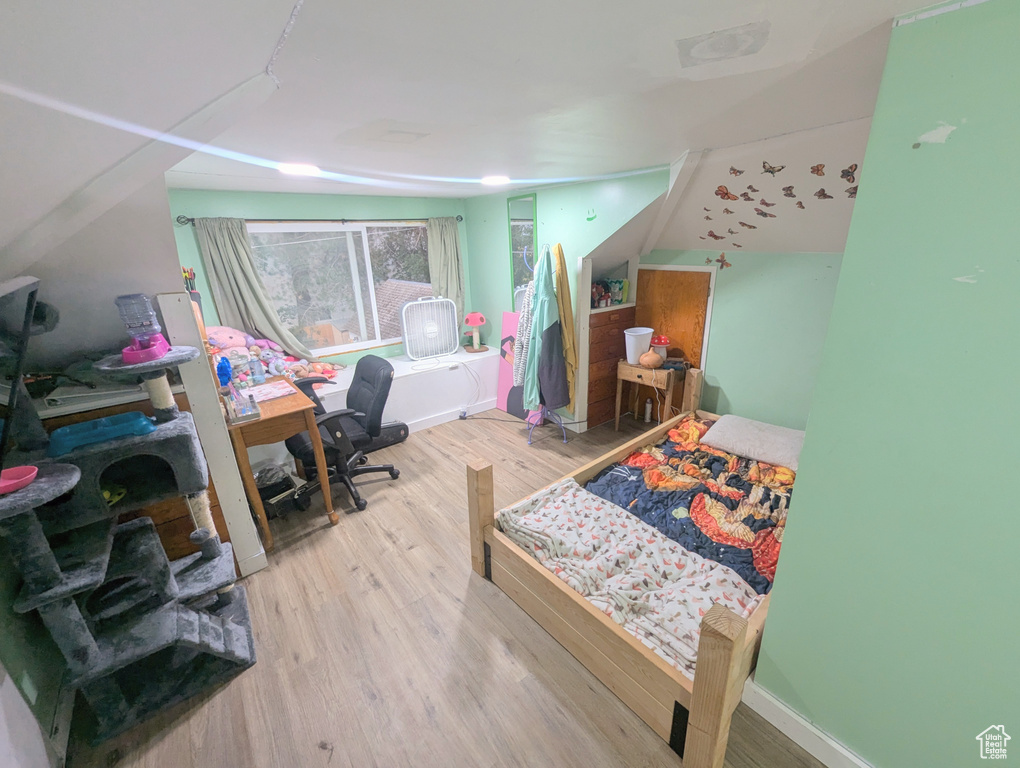 Bedroom featuring light hardwood / wood-style flooring and lofted ceiling