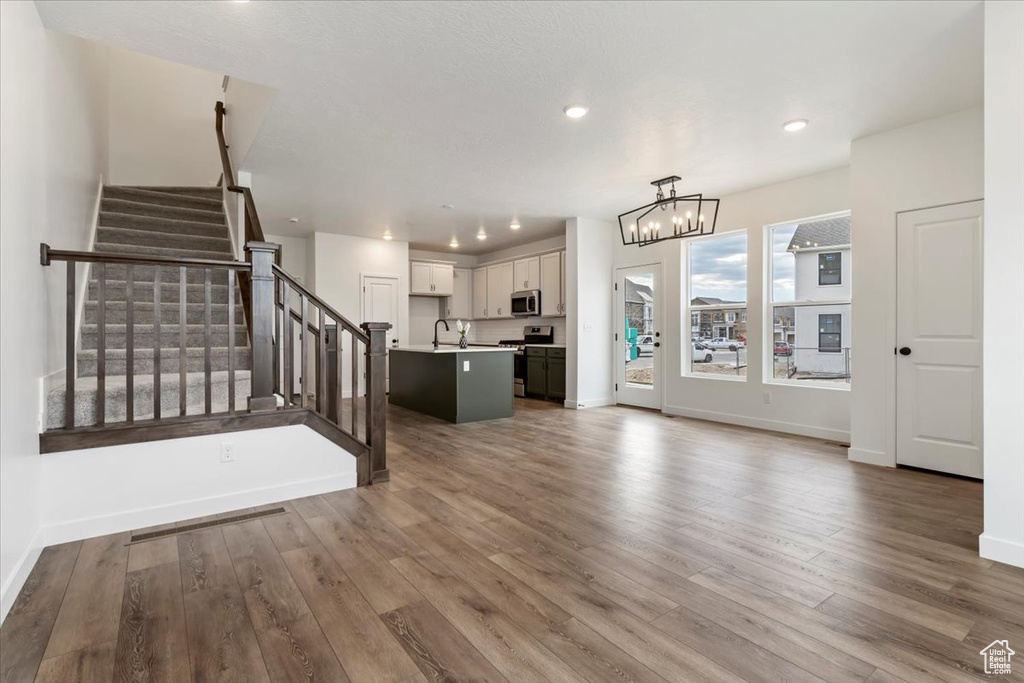 Interior space featuring sink, wood-type flooring, and a notable chandelier