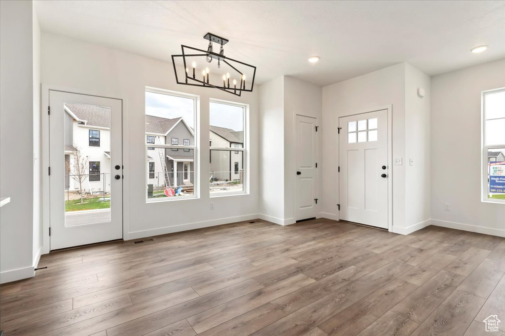 Entryway featuring light wood-type flooring and a chandelier