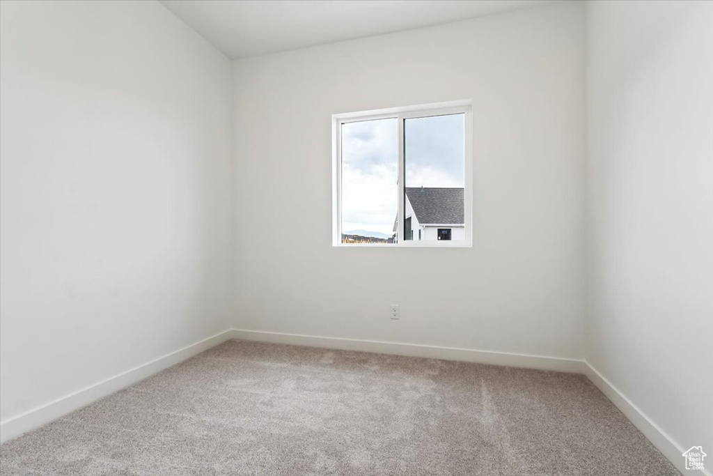 Empty room featuring light carpet