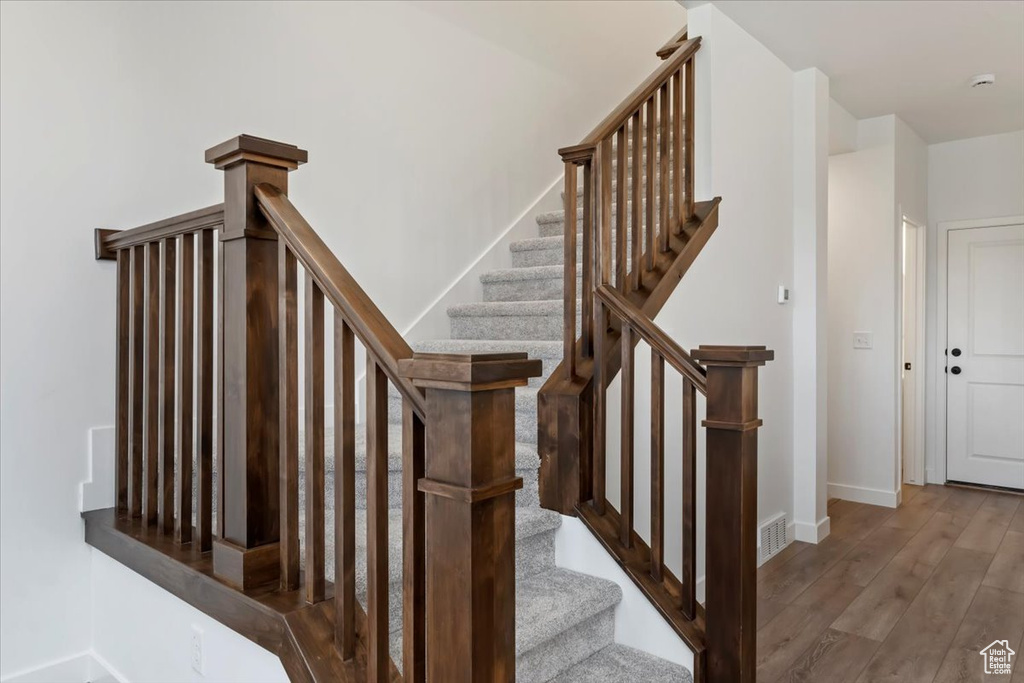 Stairs featuring hardwood / wood-style flooring