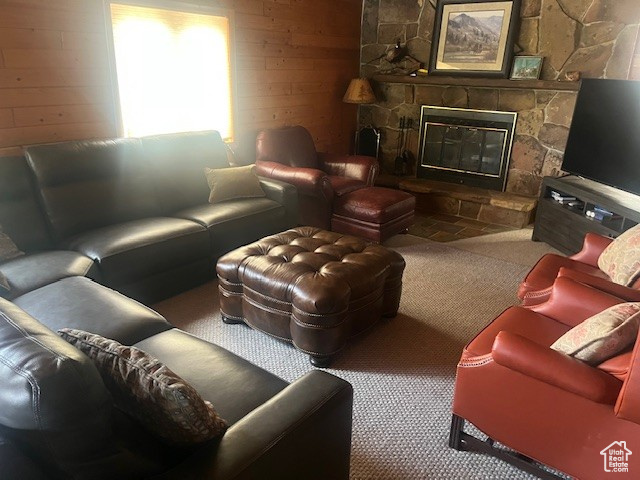 Living room featuring carpet floors and a stone fireplace