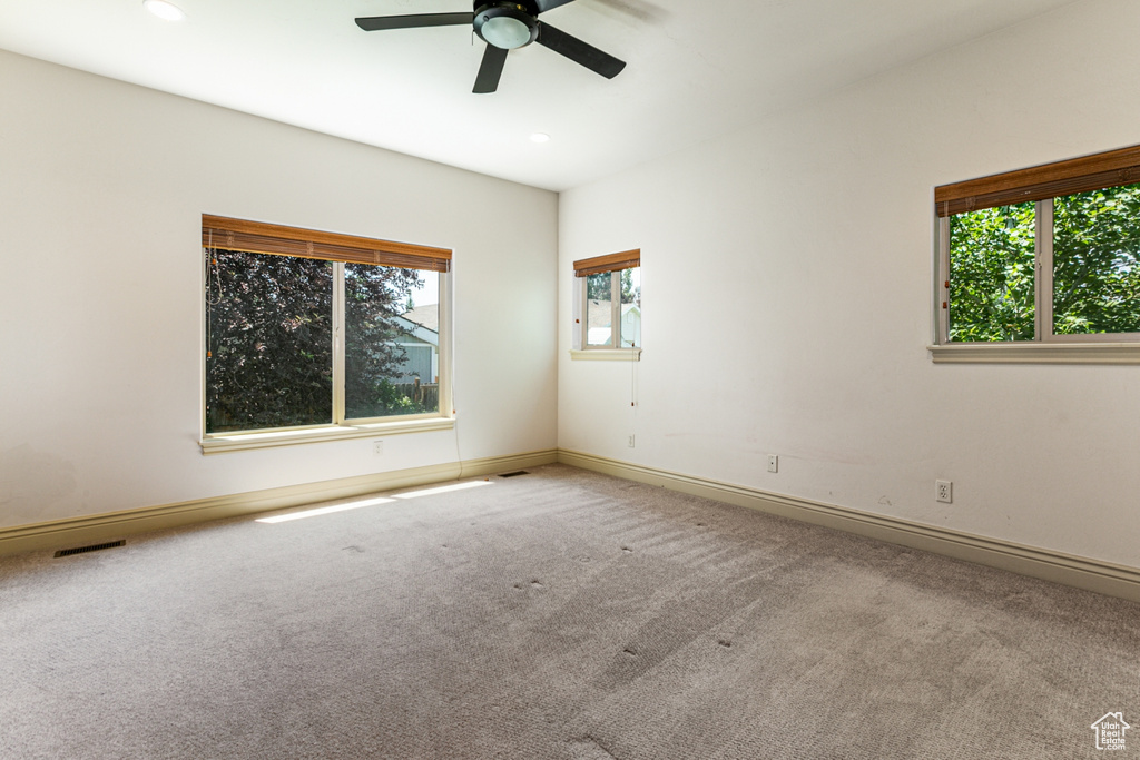 Carpeted spare room featuring ceiling fan