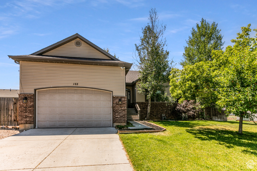 View of front of house with a garage and a front yard