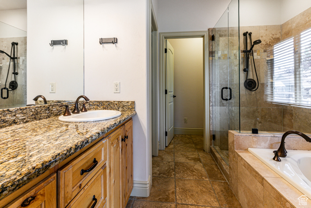 Bathroom with tile patterned floors, vanity, and separate shower and tub