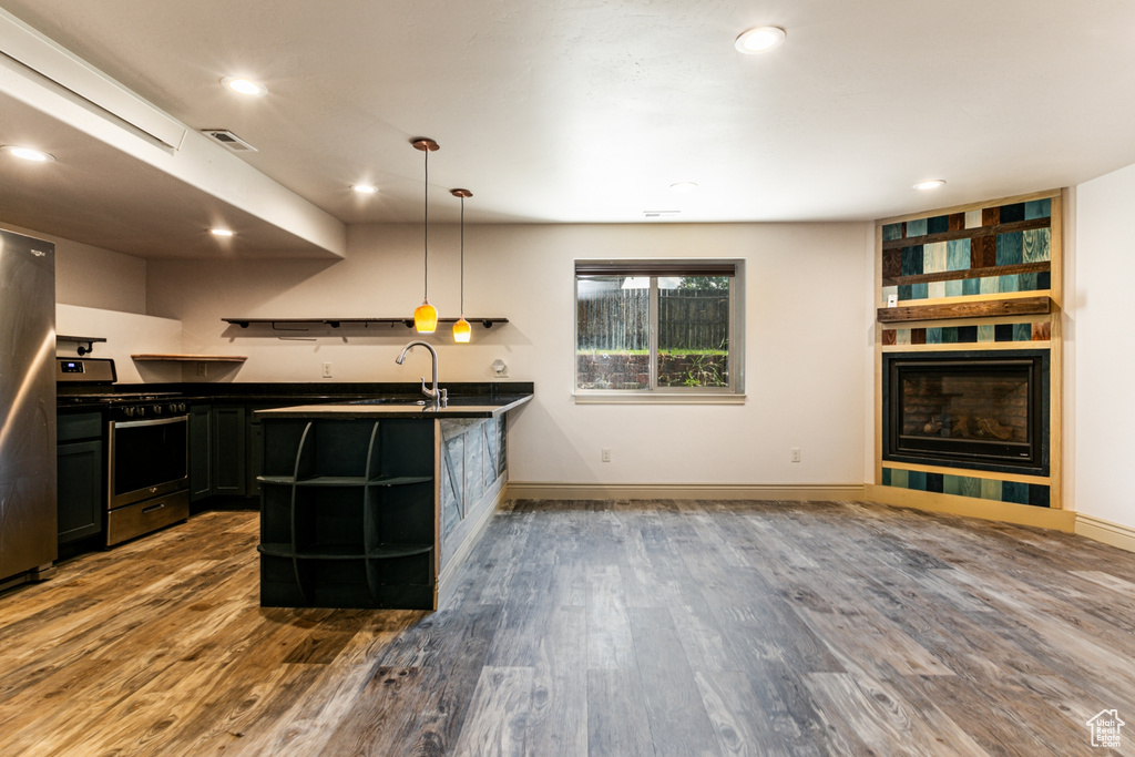 Kitchen featuring sink, appliances with stainless steel finishes, hanging light fixtures, and hardwood / wood-style floors