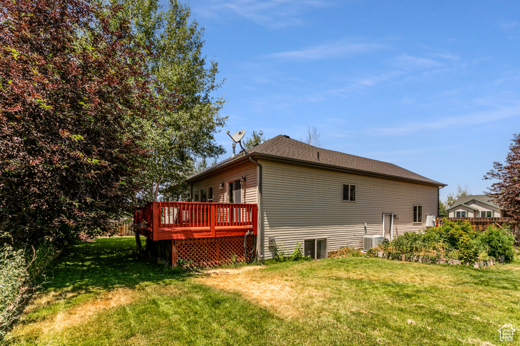 View of home's exterior featuring a deck and a yard