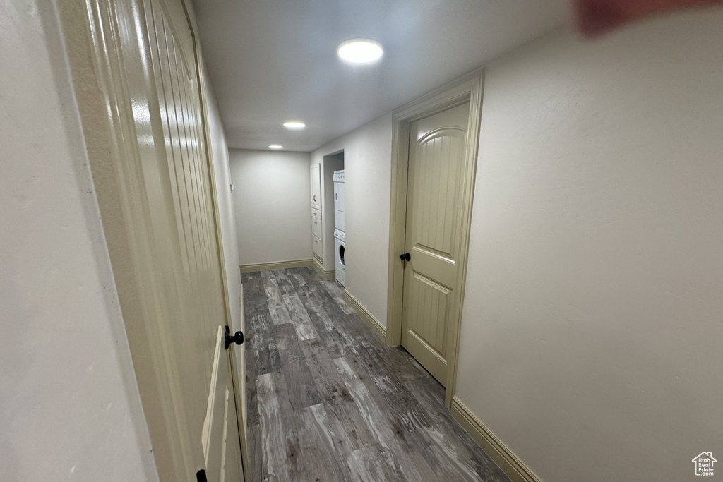 Hall featuring stacked washer / dryer and hardwood / wood-style floors