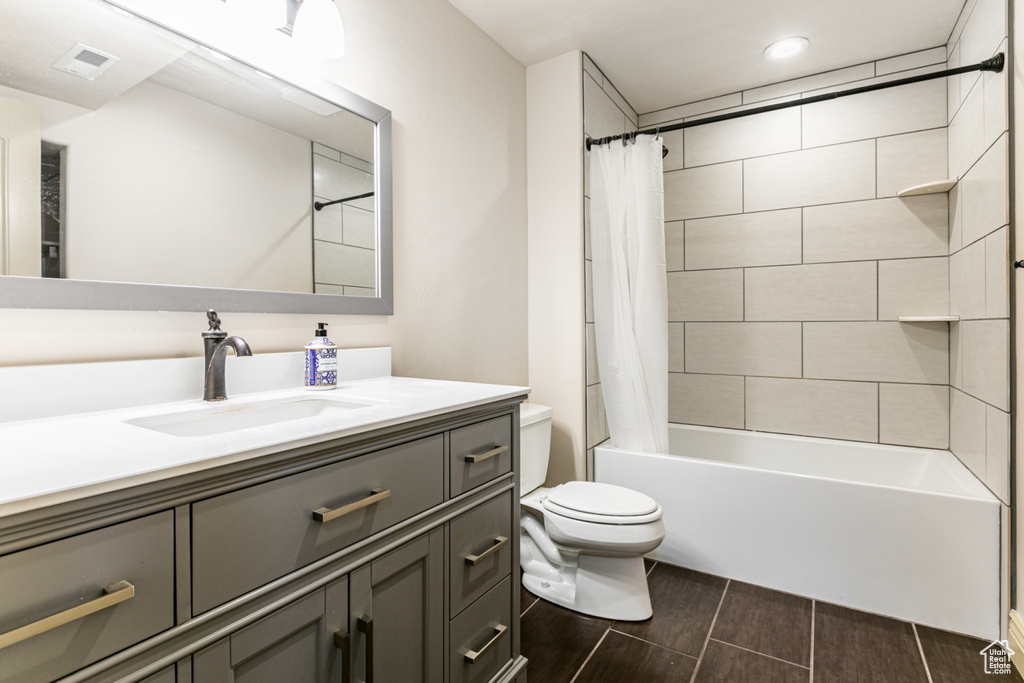 Full bathroom featuring vanity, tile patterned flooring, toilet, and shower / tub combo with curtain