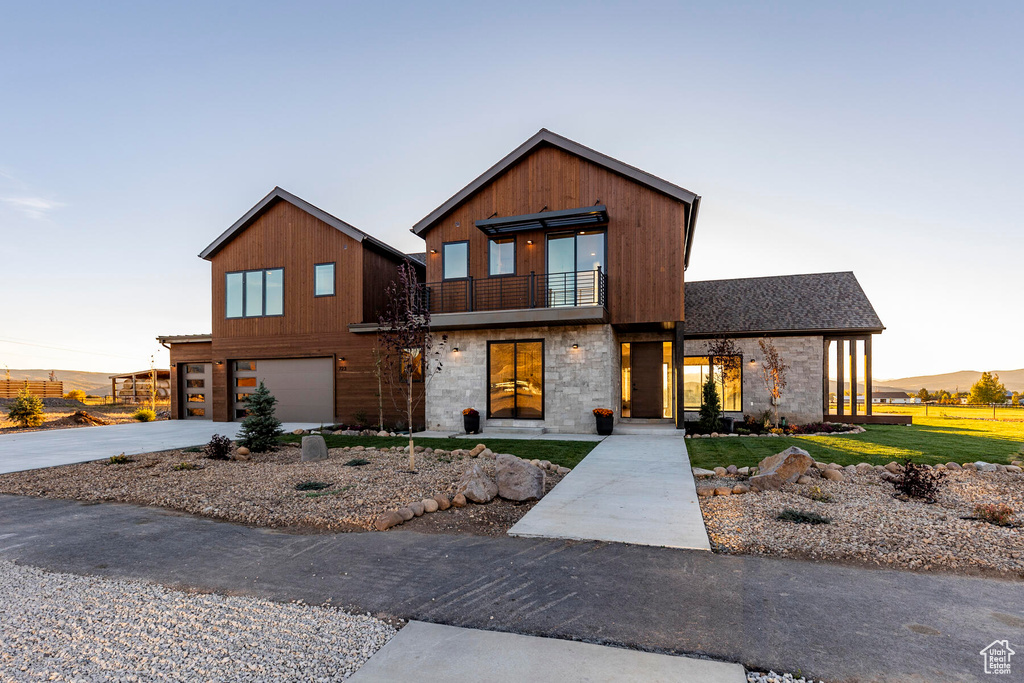 View of front of house with a garage and a balcony