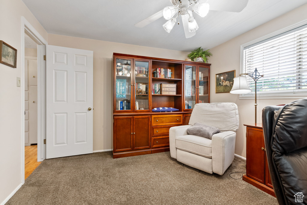 Living area featuring ceiling fan and light colored carpet