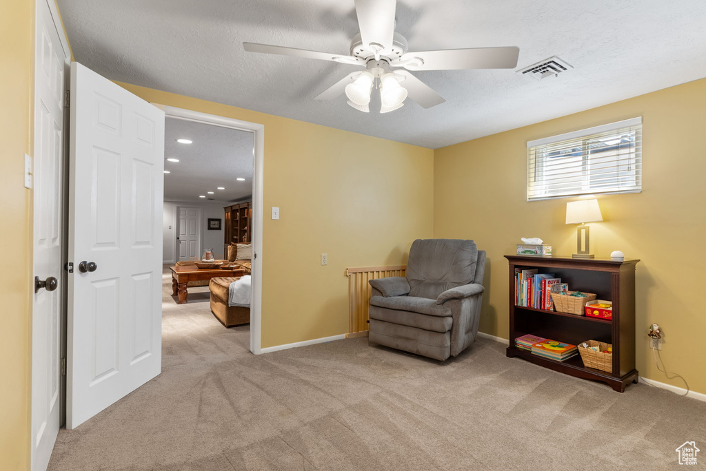 Sitting room with light carpet and ceiling fan