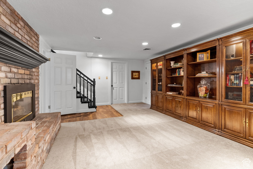 Interior space featuring a brick fireplace and light colored carpet